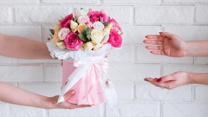 Pessoa entregando arranjo de flores para mulher - Dia das Mães