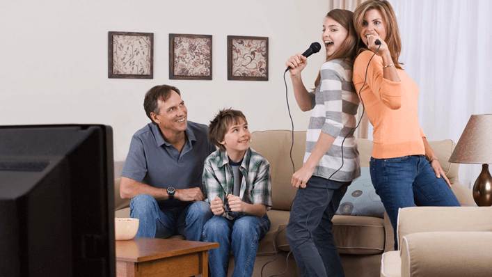 Mãe e filha cantando em karaokê na sala - dia das mães